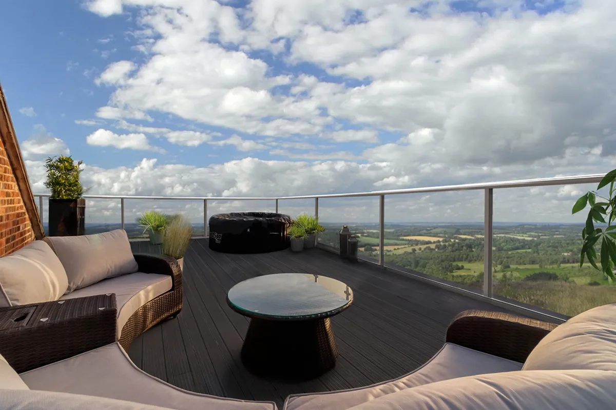 Rooftop deck at dusk with a hot tub and sofa